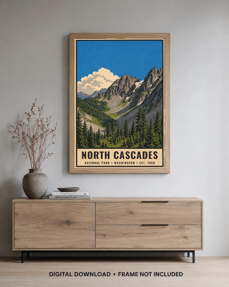 Op de afbeelding: Een verticale poster met een landschapsillustratie van het North Cascades National Park in Washington, opgericht in 1968. Het kunstwerk toont grillige bergtoppen, een diepe vallei en groenblijvende bomen onder een blauwe lucht.