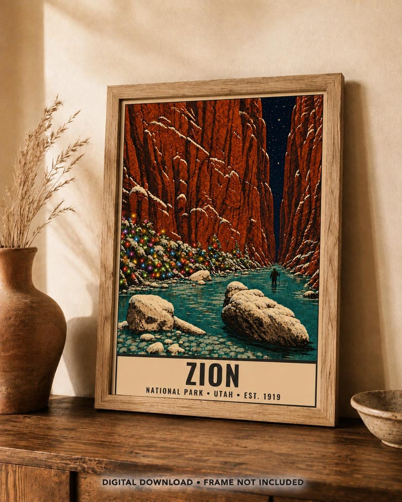 May include: A framed art print featuring a snowy Zion National Park canyon scene with a river, red rock cliffs, a starry night sky, and a decorated Christmas tree. The text at the bottom reads ZION NATIONAL PARK &bull; UTAH &bull; EST. 1919.