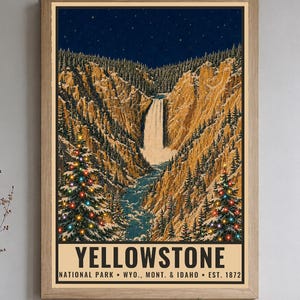 May include: A framed vertical poster depicting a winter landscape of Yellowstone National Park with a waterfall, snow-covered cliffs, and two pine trees decorated with colorful lights under a starry night sky. The text reads YELLOWSTONE NATIONAL PARK &bull; WYO., MONT. & IDAHO &bull; EST. 1872.