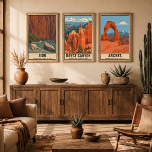 Może przedstawiać: Trzy prostokątne plakaty ścienne z ilustracjami park&oacute;w narodowych Zion, Bryce Canyon i Arches. Każdy wydruk zawiera nazwę parku, lokalizację oraz rok założenia. Obrazy są oprawione w ramy i powieszone w jednym poziomym rzędzie.