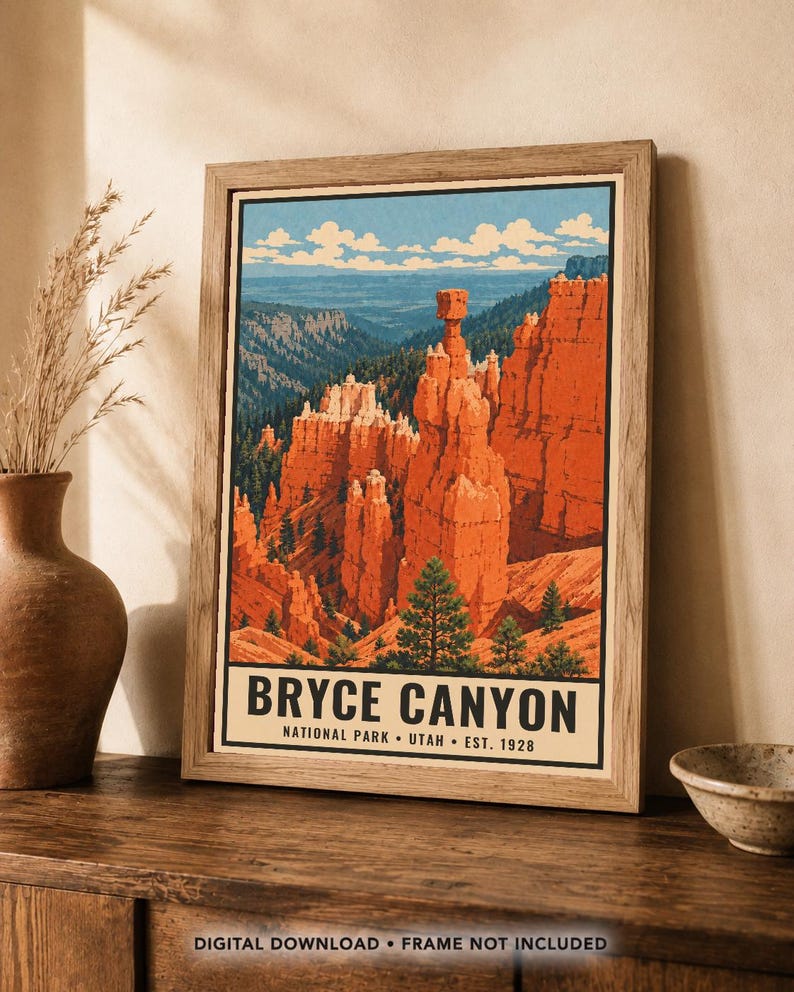 Op de afbeelding: Een ingelijste poster met een gestileerde illustratie van Bryce Canyon National Park in Utah. Het kunstwerk toont oranje rotsformaties, groene dennenbomen en een blauwe lucht met wolken. De tekst luidt BRYCE CANYON NATIONAL PARK UTAH EST. 1928.