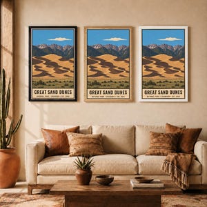 K&ouml;nnte beinhalten: Drei vertikale Wandkunstdrucke, die den Great Sand Dunes Nationalpark in Colorado darstellen. Jeder Druck zeigt eine Landschaft aus beigen Sandd&uuml;nen, dunklen Bergen und einem blauen Himmel mit dem Text GREAT SAND DUNES NATIONAL PARK COLORADO EST. 2004.