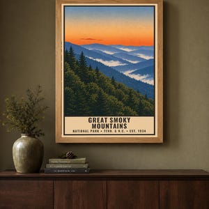 Może przedstawiać: Oprawiony pionowy plakat z ilustracją krajobrazu Parku Narodowego Great Smoky Mountains. Grafika przedstawia zielone lasy sosnowe na pierwszym planie, niebieskie pasma g&oacute;rskie i żywe pomarańczowe niebo o zachodzie.