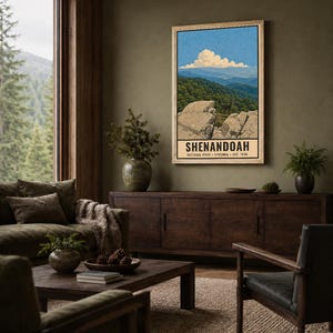 Op de afbeelding: Een verticale rechthoekige wandprint met een landschapsillustratie van Shenandoah National Park. Het kunstwerk toont rotsachtige kliffen op de voorgrond, een dicht groen bos, verre blauwe bergkammen en een witte wolk in een blauwe lucht.