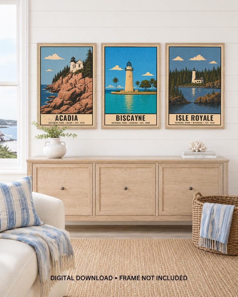 Może przedstawiać: Trzy oprawione pionowe wydruki artystyczne z ilustracjami latarni morskich w parkach narodowych Acadia, Biscayne i Isle Royale. Każdy wydruk zawiera nazwę parku, lokalizację i rok założenia czarnym tekstem u dołu obrazu.