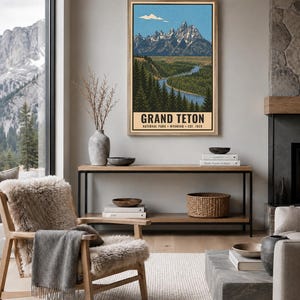 K&ouml;nnte beinhalten: Ein vertikaler Wandkunstdruck mit einer stilisierten Illustration des Grand-Teton-Nationalparks in Wyoming, gegr&uuml;ndet 1929. Das Kunstwerk zeigt schneebedeckte Berggipfel, einen gewundenen Fluss und dichte Kiefernw&auml;lder in einer blau-gr&uuml;nen Farbpalette.
