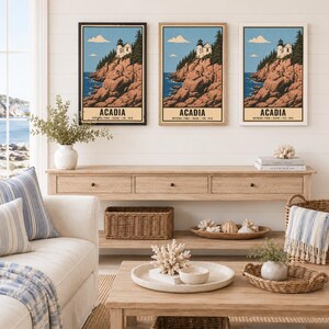 May include: Three framed wall art prints depicting a lighthouse on a rocky cliffside in Acadia National Park, Maine. Each print features a blue sky, evergreen trees, and the text ACADIA NATIONAL PARK MAINE EST. 1919. The frames are black, wood, and white.
