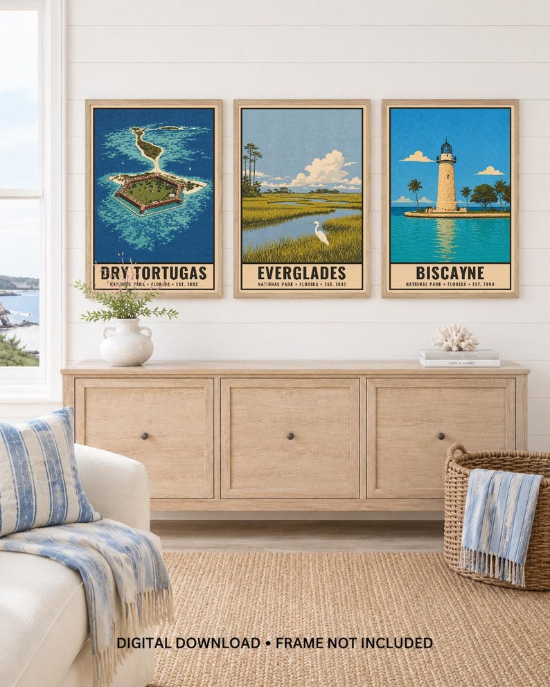 May include: Three framed vertical art prints featuring Florida national parks. The left print shows Dry Tortugas, the centre print depicts the Everglades with a white bird, and the right print displays the Biscayne lighthouse. Text includes park names.