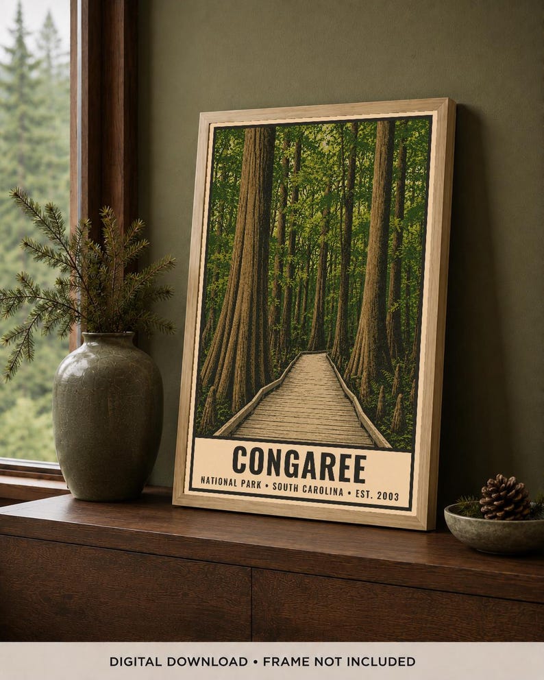 May include: A framed vertical poster featuring a detailed illustration of a wooden boardwalk winding through a dense forest of tall trees. The text at the bottom reads CONGAREE NATIONAL PARK SOUTH CAROLINA EST. 2003 in bold black capital letters.