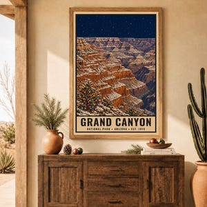 May include: A framed vertical poster depicting the Grand Canyon in Arizona under a starry night sky. The canyon walls are dusted with snow, and a decorated Christmas tree with colorful lights stands in the foreground. Text reads GRAND CANYON.