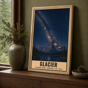 May include: A framed vertical wall art print featuring a night landscape of a mountain peak reflected in a lake under a starry sky with the Milky Way visible. The bottom border contains the text GLACIER NATIONAL PARK MONTANA EST. 1910.