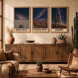 May include: Three rectangular wall art prints in wooden frames featuring night sky landscapes of Death Valley, Petrified Forest, and Saguaro National Parks. Each print displays a starry galaxy above desert terrain and includes text labels.