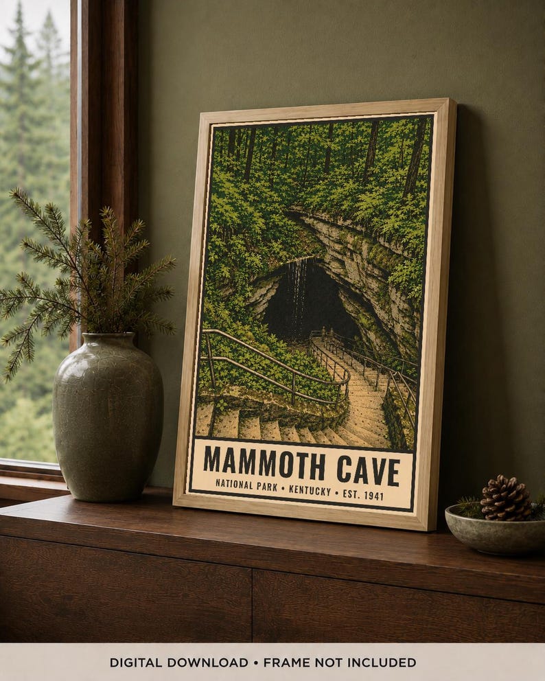 May include: A framed vertical poster depicting the entrance to Mammoth Cave National Park in Kentucky. The illustration features a stone staircase leading into a dark cave opening surrounded by lush green trees, with the text Mammoth Cave National Park Kentucky Est. 1941 printed at the bottom.