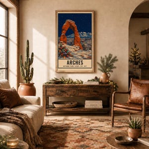 May include: A vertical rectangular wall art print featuring a stylized illustration of the red rock Delicate Arch in Arches National Park, Utah, under a starry night sky, with a decorated Christmas tree and the text ARCHES NATIONAL PARK UTAH EST. 1971.