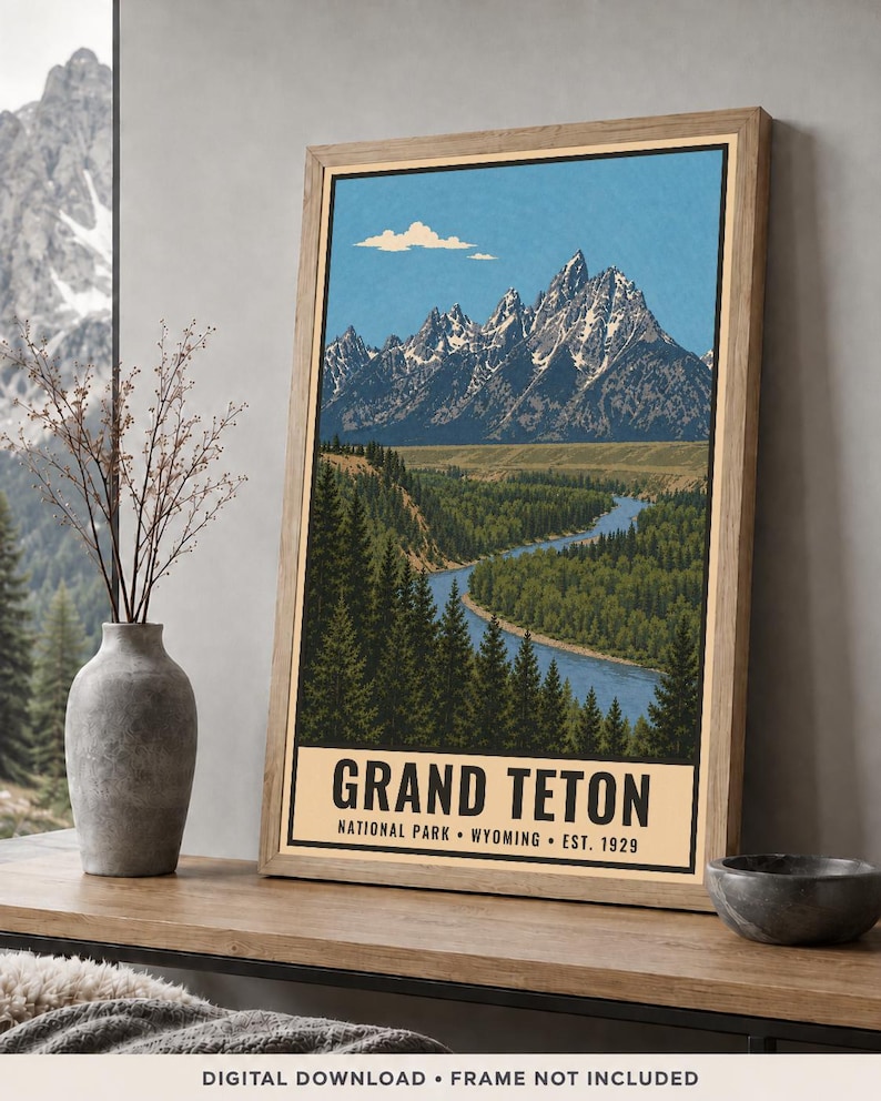 K&ouml;nnte beinhalten: Ein gerahmtes vertikales Poster mit einer Landschaftsillustration des Grand-Teton-Gebirges mit schneebedeckten Gipfeln, einem gewundenen blauen Fluss und dichten gr&uuml;nen Kiefernw&auml;ldern. Der Text lautet GRAND TETON NATIONAL PARK WYOMING EST. 1929.