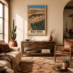 Pu&ograve; includere: Una stampa artistica da parete verticale con un'illustrazione dettagliata delle abitazioni rupestri di Mesa Verde in Colorado. L'opera mostra formazioni rocciose color marrone chiaro, alberi verdi e un cielo blu brillante, con il testo MESA VERDE NATIONAL PARK COLORADO EST. 1906.