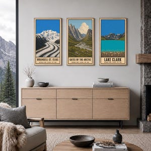 K&ouml;nnte beinhalten: Drei vertikale Wandkunstdrucke mit Illustrationen der Nationalparks Wrangell-St. Elias, Gates of the Arctic und Lake Clark. Jeder Druck zeigt eine Landschaft mit Bergen, Gletschern oder Seen und enth&auml;lt den Parknamen in schwarzer Schrift.