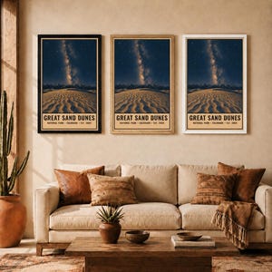 May include: Three vertical wall art prints featuring the Great Sand Dunes National Park in Colorado, established in 2004. Each print displays a night sky with the Milky Way over sand dunes, framed in black, light wood, and white frames respectively.