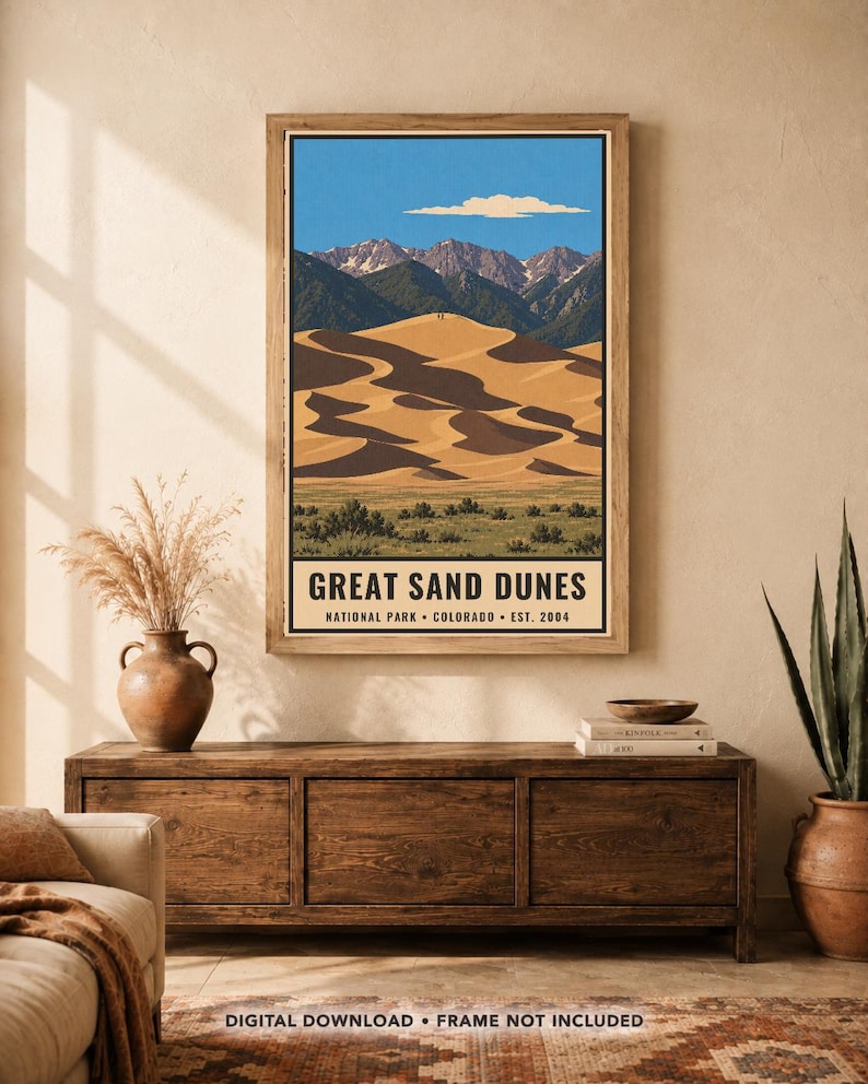 K&ouml;nnte beinhalten: Ein vertikaler Wandkunstdruck mit einer stilisierten Illustration des Great Sand Dunes Nationalparks in Colorado. Das Bild zeigt goldene Sandd&uuml;nen, gr&uuml;ne Vegetation, dunkle Berge und einen blauen Himmel mit einer einzelnen Wolke. Der Text lautet: GREAT SAND DUNES NATIONAL PARK &bull; COLORADO &bull; EST. 2004.