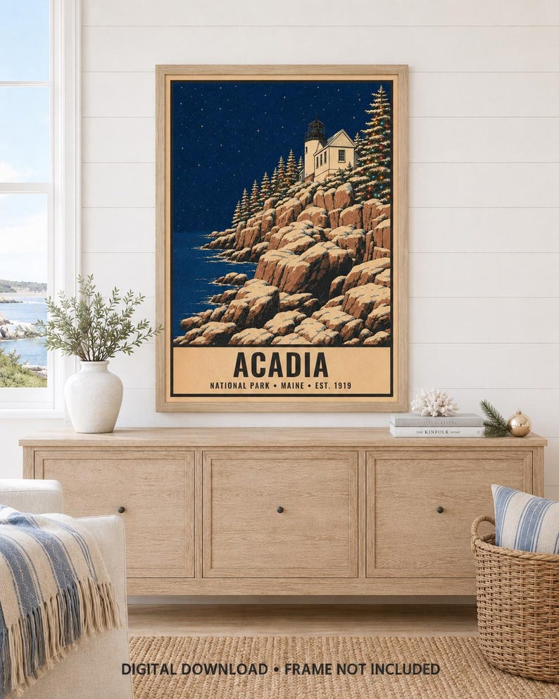 Puede incluir: Una l&aacute;mina de arte mural enmarcada que muestra un paisaje nocturno del Parque Nacional Acadia en Maine. La ilustraci&oacute;n representa un faro en un acantilado rocoso con &aacute;rboles de hoja perenne bajo un cielo estrellado. El texto dice ACADIA NATIONAL PARK MAINE EST. 1919.