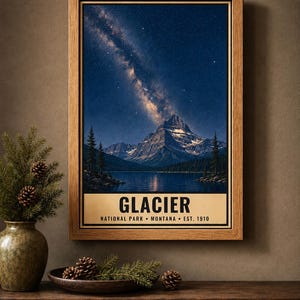 May include: A framed vertical wall art print featuring a night landscape of a mountain range and a lake under a starry sky with the Milky Way. The text at the bottom reads GLACIER NATIONAL PARK MONTANA EST. 1910 in black capital letters.