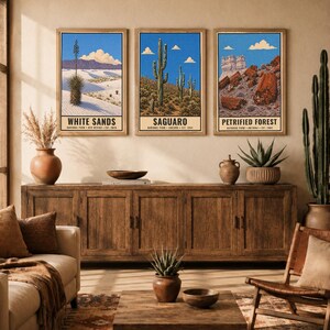 May include: Three rectangular wall art prints featuring illustrations of White Sands, Saguaro, and Petrified Forest National Parks. Each print displays a blue sky, landscape scenery, and the park name in bold black text at the bottom of the frame.