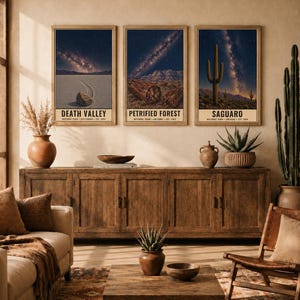 May include: Three rectangular wall art prints in wooden frames featuring night sky landscapes of Death Valley, Petrified Forest, and Saguaro National Parks. Each print displays a starry galaxy above desert terrain and includes text labels.