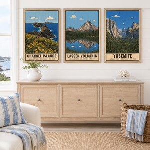 May include: Three vertical wall art prints featuring illustrations of Channel Islands, Lassen Volcanic, and Yosemite National Parks. Each print displays a landscape scene with blue skies, mountains, and text identifying the park name and location.