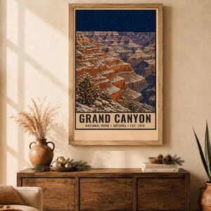 Puede incluir: Un p&oacute;ster vertical que muestra un paisaje nevado del Gran Ca&ntilde;&oacute;n bajo un cielo azul oscuro estrellado. Un pino decorado con luces de colores se encuentra en primer plano. El texto dice GRAND CANYON NATIONAL PARK ARIZONA EST. 1919.