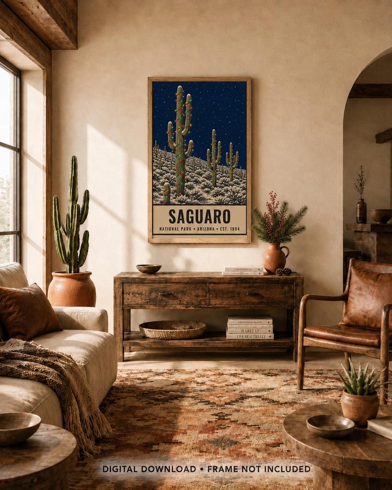 May include: A rectangular wall art print featuring a dark blue night sky with stars over a desert landscape of saguaro cacti. The bottom section contains the text SAGUARO NATIONAL PARK ARIZONA EST. 1994 in black capital letters on a cream background.