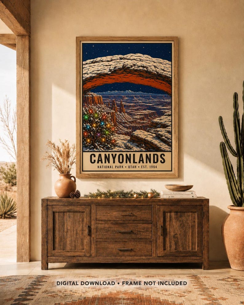 May include: A framed vertical poster print featuring a night landscape of Canyonlands National Park in Utah. The artwork displays a natural stone arch, a starry sky, and a decorated Christmas tree with colorful lights. Text reads CANYONLANDS.