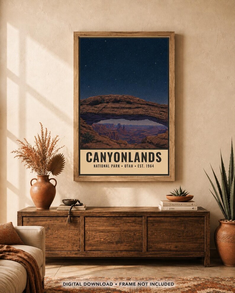 May include: A vertical rectangular wall art print featuring a night sky over a natural rock arch in Canyonlands National Park, Utah. The text reads CANYONLANDS NATIONAL PARK UTAH EST. 1964. The print is displayed in a wooden frame on a wall.