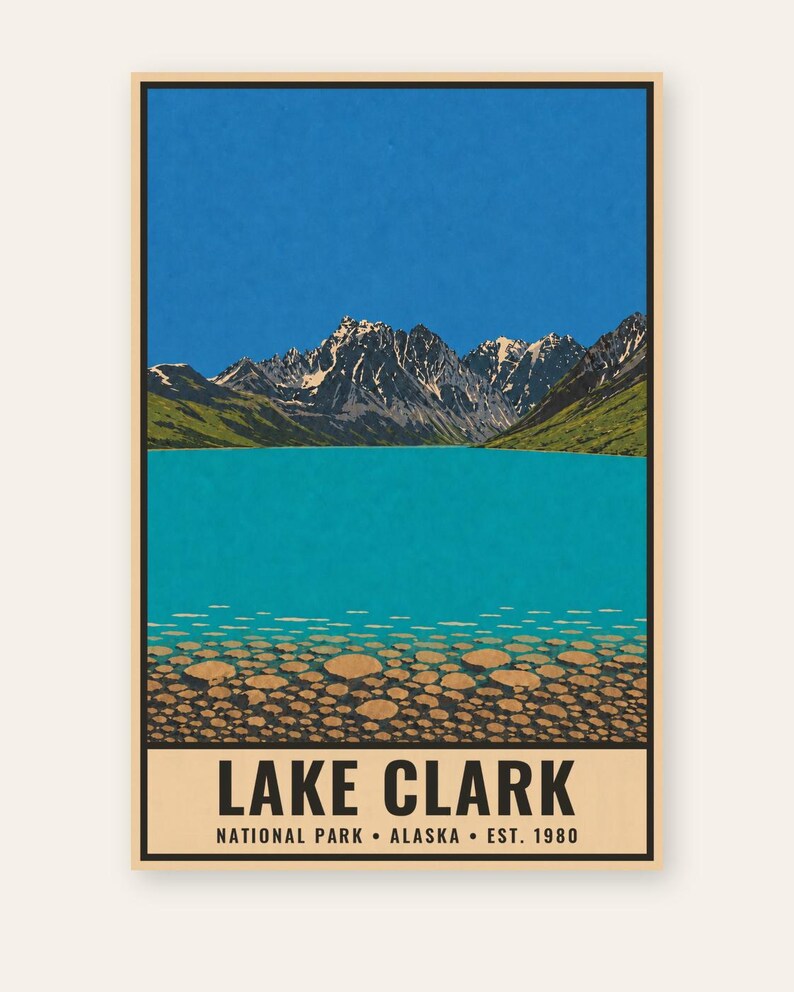Pode incluir: Um cartaz retangular com uma ilustra&ccedil;&atilde;o da paisagem do Lago Clark no Alasca. A cena mostra um c&eacute;u azul brilhante, montanhas escarpadas cobertas de neve, colinas verdes e um lago turquesa com pedras redondas vis&iacute;veis no fundo. O texto diz LAKE CLARK NATIONAL PARK ALASKA EST. 1980.