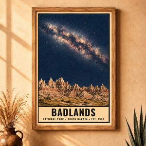 K&ouml;nnte beinhalten: Ein rechteckiger gerahmter Wandkunstdruck, der einen sternenklaren Nachthimmel &uuml;ber den geschichteten Felsformationen des Badlands Nationalparks zeigt. Der Text am unteren Rand lautet BADLANDS NATIONAL PARK SOUTH DAKOTA EST. 1978.