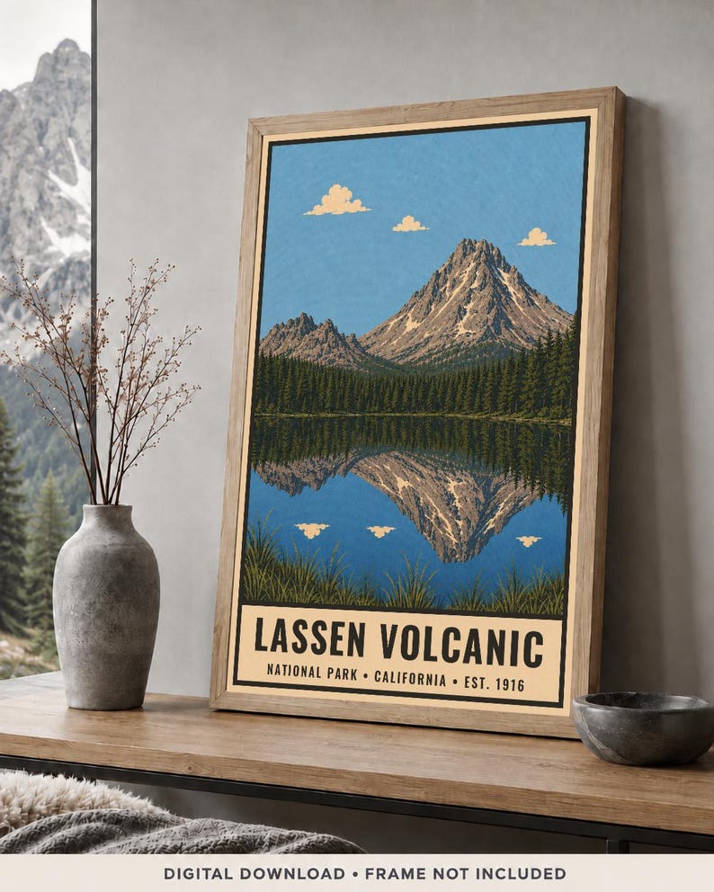 K&ouml;nnte beinhalten: Ein gerahmter Kunstdruck mit einer Landschaftsillustration des Lassen Volcanic Nationalparks in Kalifornien. Das Bild zeigt einen Berggipfel, der sich in einem See spiegelt, umgeben von Kiefern, mit dem Text Lassen Volcanic National Park California Est. 1916.