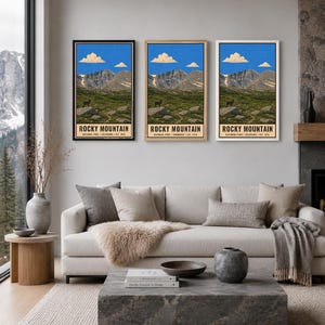 May include: Three identical vertical wall art prints featuring a landscape of Rocky Mountain National Park with a blue sky, white clouds, rocky peaks, green meadows, and a small animal on a rock, labelled with the text Rocky Mountain National Park.