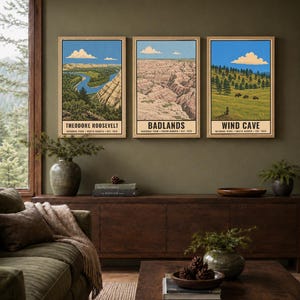May include: Three vertical rectangular wall art prints featuring illustrations of Theodore Roosevelt, Badlands, and Wind Cave National Parks. Each print displays a landscape scene under a blue sky with white clouds and includes text at the bottom.