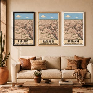 K&ouml;nnte beinhalten: Drei identische vertikale Wandkunstdrucke, die den Badlands-Nationalpark in South Dakota darstellen. Jeder Druck zeigt eine Landschaft aus geschichteten Felsformationen unter einem blauen Himmel mit Wolken und den Text BADLANDS NATIONAL PARK SOUTH DAKOTA EST. 1978.