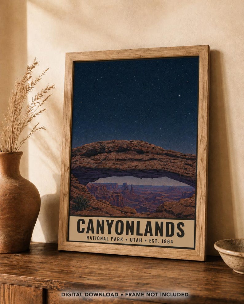 May include: A framed vertical poster featuring a night sky filled with stars above a natural rock arch and canyon landscape. The bottom section contains the text CANYONLANDS NATIONAL PARK UTAH EST. 1964 in black capital letters on a beige background.