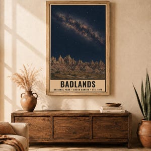 K&ouml;nnte beinhalten: Ein vertikales, rechteckiges Wandbild, das einen sternenklaren Nachthimmel mit der Milchstra&szlig;e &uuml;ber den zerkl&uuml;fteten Felsformationen des Badlands-Nationalparks zeigt. Der Text lautet BADLANDS NATIONAL PARK SOUTH DAKOTA EST. 1978.