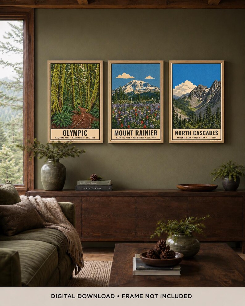 Op de afbeelding: Drie verticale kunstprints in lichte houten lijsten met illustraties van de nationale parken Olympic, Mount Rainier en North Cascades. Elke print toont een landschap met tekst onderaan. Digitale download, lijst niet inbegrepen.