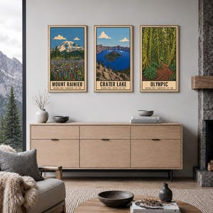 K&ouml;nnte beinhalten: Drei vertikale Wandkunstdrucke mit Illustrationen der Nationalparks Mount Rainier, Crater Lake und Olympic. Jeder Druck zeigt eine Landschaftsszene mit Text am unteren Rand, der den Park, den Bundesstaat und das Gr&uuml;ndungsjahr angibt.