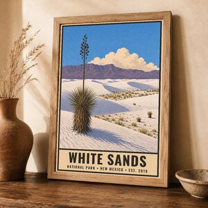 May include: A framed art print featuring a landscape illustration of White Sands National Park in New Mexico. The image displays white sand dunes, a yucca plant, distant mountains, and a blue sky with clouds. The text reads WHITE SANDS NATIONAL PARK NEW MEXICO EST. 2019.
