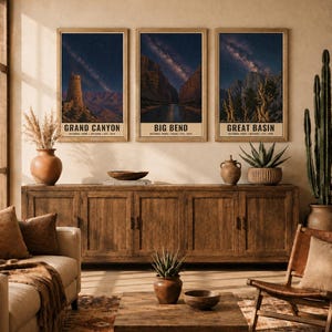 May include: Three vertical posters in wooden frames depicting the Grand Canyon, Big Bend, and Great Basin national parks under starry night skies. Each print features the park name, location, and establishment year at the bottom of the image.