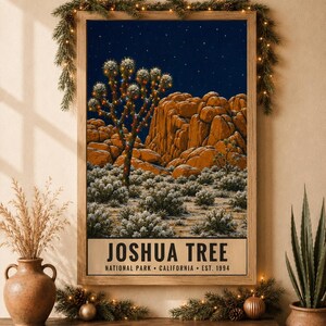 May include: A rectangular framed wall art print featuring a Joshua Tree National Park landscape at night. The image shows a Joshua tree decorated with colorful string lights, orange rock formations, and a starry sky. Text reads JOSHUA TREE.