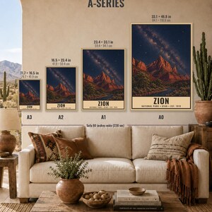May include: Four framed wall art prints of Zion National Park displayed in A3, A2, A1, and A0 sizes above a sofa. Each print features a night sky with a milky way over red rock mountains and the text Zion National Park Utah Est. 1919.
