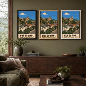 Peut inclure: Trois affiches verticales identiques pr&eacute;sentant une illustration de style vintage du parc national de Hot Springs, Arkansas, &eacute;tabli en 1921. L'&oelig;uvre repr&eacute;sente un paysage urbain avec des b&acirc;timents, des arbres et un ciel bleu. Le texte indique HOT SPRINGS.