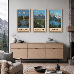 Może przedstawiać: Trzy pionowe oprawione wydruki artystyczne przedstawiające parki narodowe Isle Royale, Grand Teton i Glacier. Każdy wydruk zawiera ilustrację krajobrazu z błękitnym niebem, g&oacute;rami, lasami i wodą, z nazwą parku wydrukowaną na dole.