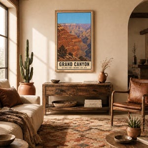 K&ouml;nnte beinhalten: Ein vertikaler Wandkunstdruck mit einer Landschaftsillustration des Grand Canyon mit roten Felsformationen und blauem Himmel. Der Text am unteren Rand lautet GRAND CANYON NATIONAL PARK ARIZONA EST. 1919. Der Druck befindet sich in einem Holzrahmen.