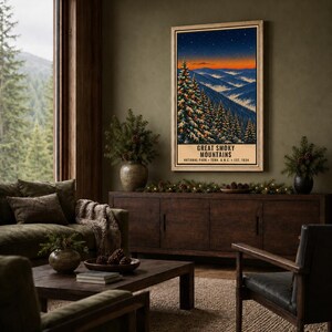 May include: A vertical rectangular wall art print featuring a landscape of the Great Smoky Mountains at twilight. The scene depicts snow-covered pine trees in the foreground, rolling blue mountain ridges, and a vibrant orange sunset sky.